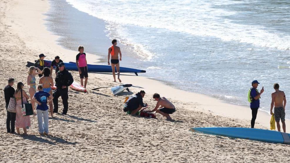 Police officers speak to people following a shark attack at Coogee Beach in Sydney, Australia. Photo: 13 June 2026