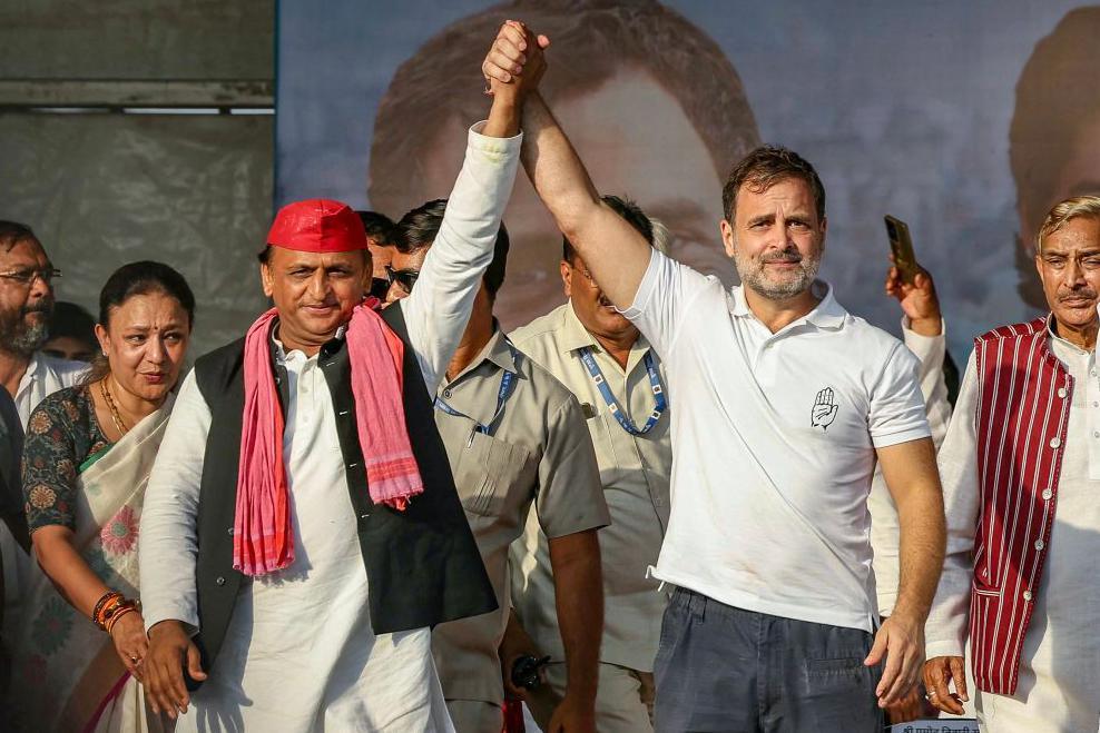 Indian National Congress (INC) Party leader Rahul Gandhi (2R) and Samajwadi Party President Akhilesh Yadav (C) gesture as they arrive to attend an election rally of Indian National Developmental Inclusive Alliance (INDIA) on the outskirts of Varanasi on May 28, 2024, during country's ongoing general election