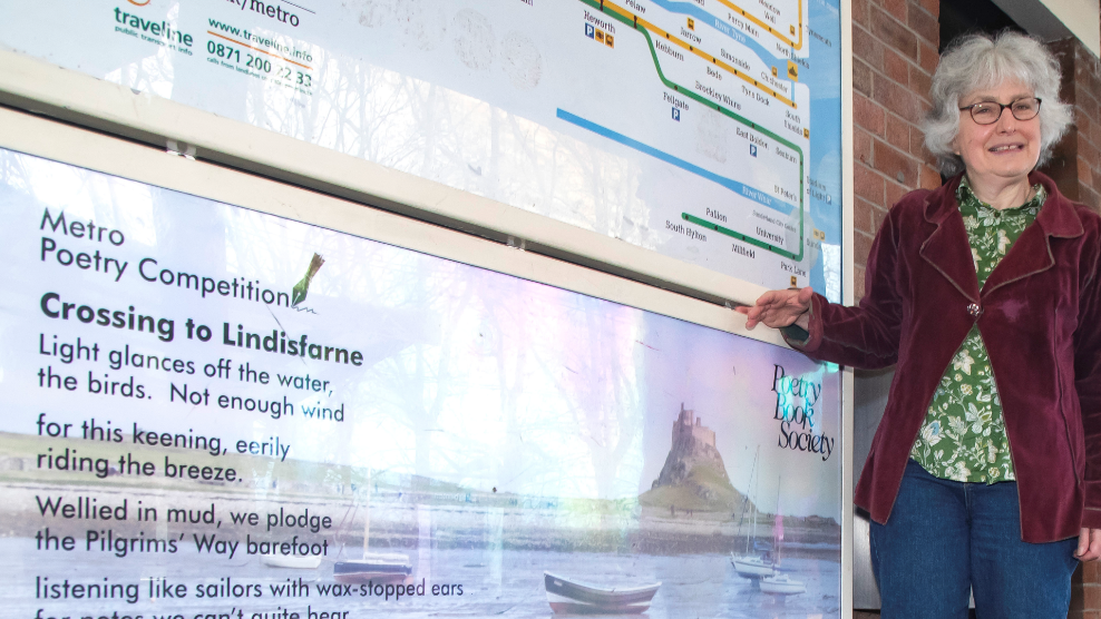 Claire Lynn next to a poster displaying her poem