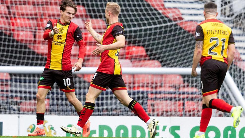 Logan Chalmers celebrates with Harry Milne and Aiden Fitzpatrick