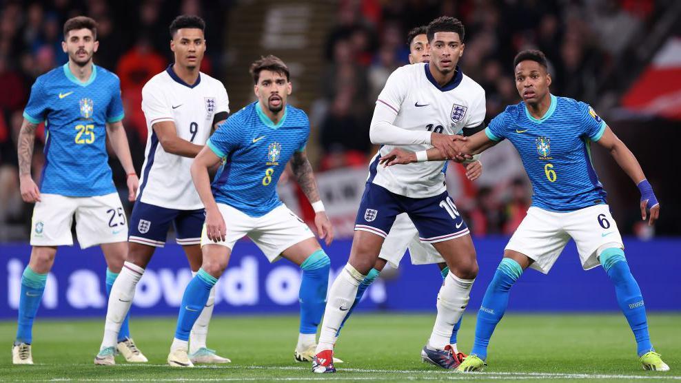 England's Jude Bellingham and Brazil's Wendell tussle while waiting wait for a free-kick to be delivered into the penalty area in March 2024