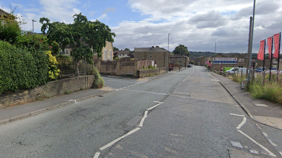 The junction of Westcliffe Road and the main road, Westgate, in Cleckheaton, with a blue, cloudy sky above.