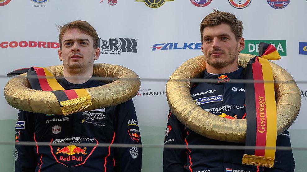 Max Verstappen on the podium at the Nurburgring alongside British racing driver Chris Lulham