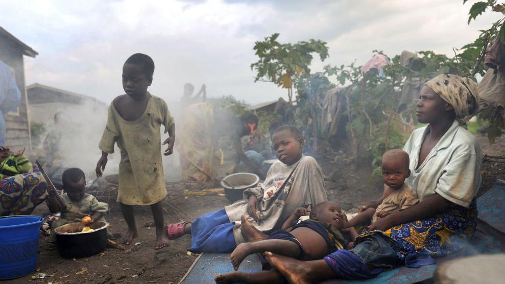 A Congolese woman, displaced from a surrounding village, sits with three children on a mat inside Kibati camp in Goma, North Kivu province, Democratic Republic of the Congo on Nov. 26, 2008. Civilians on both sides of the front lines in eastern Congo are being killed, raped and abducted by both Tutsi rebels and government troops