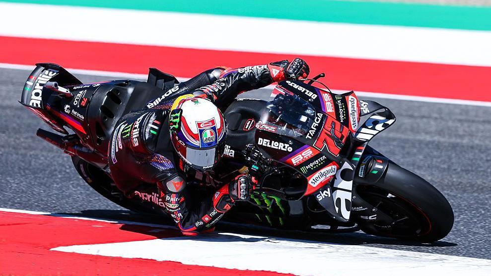 Marco Bezzecchi leans low to his right as he takes a corner