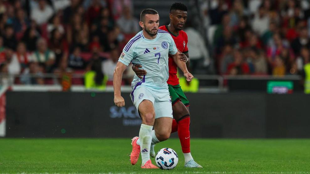 Scottish football John McGinn tries to escape Nelson Semedo of Portugal (B) during the UEFA Nations League 2024/25 League A Group A1 match between Portugal and Scotland at on September 8, 2024 in Lisbon, Portugal.