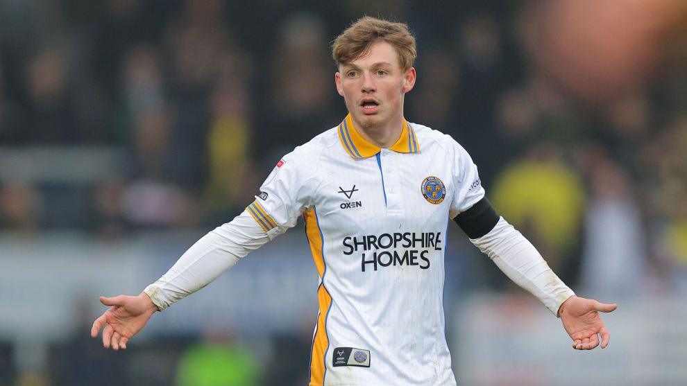 Tommi O'Reilly stretches his arms out wide asking for the ball during a game for Shrewsbury Town