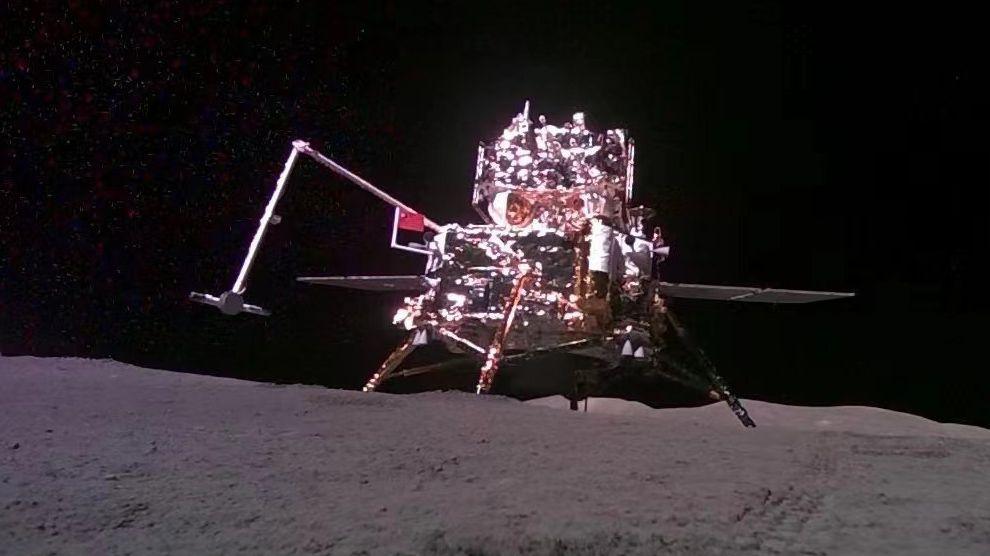 The  Chinese lander-ascender mooncraft is pictured while being captured from the 'mobile camera' carried by the Chang'e-6 probe (out of frame), as it holds out  a Chinese flag while stood on the surface of the moon against the dark abyss of space during China's moon mission on 4 June, 2024.