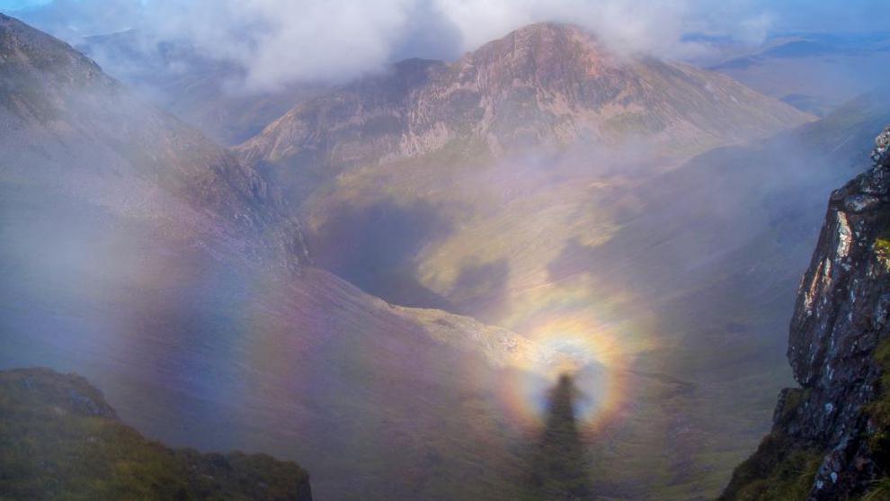 Brocken spectre reflected on cloud in Glen Coe's mountain landscape