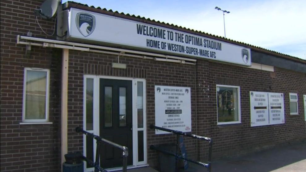 The front of the building for the football club, with rails leading to the door and a sign saying 'welcome to optima stadium'. 