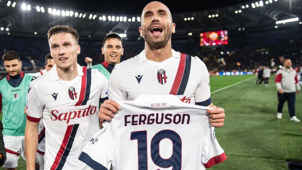 Bologna's Lorenzo de Silvestri celebrates with Lewis Ferguson's shirt after the win at Roma