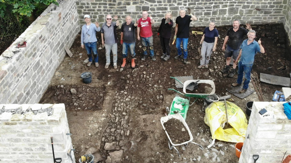 Volunteers waving from inside the restored village pound