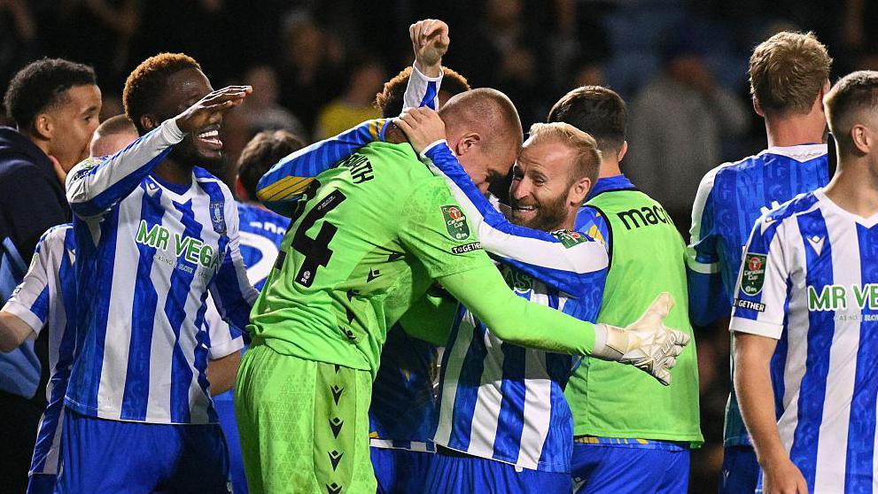 Barry Bannan (centre) hugs goalkeeper Ethan Horvath after they beat Premier League Leeds on penalties in the EFL Cup