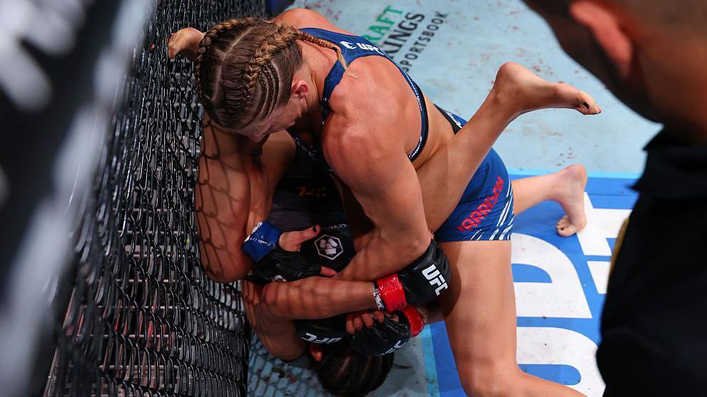 Kayla Harrison fights to grab Julianna Pena's arm for a submission