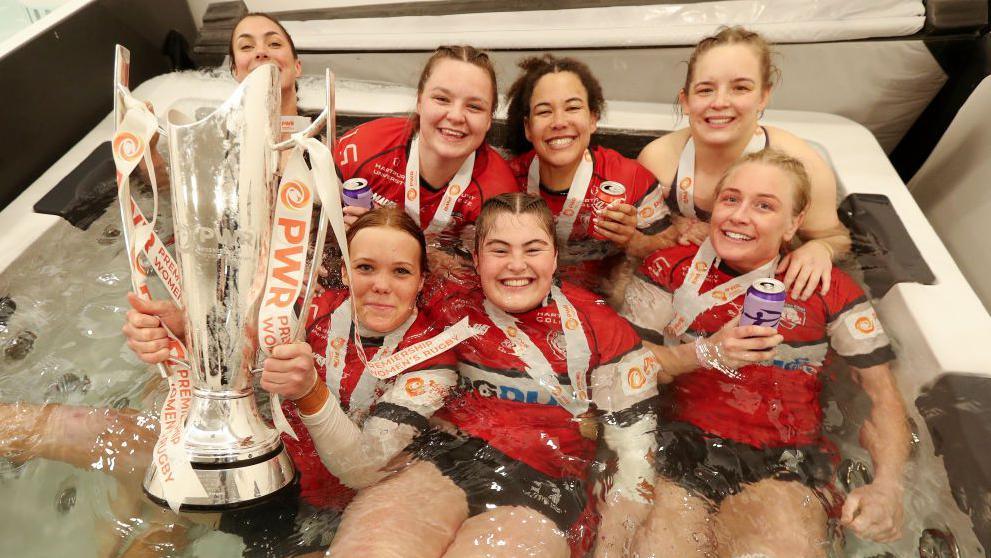 Gloucester-Hartpury players celebrate with PWR trophy