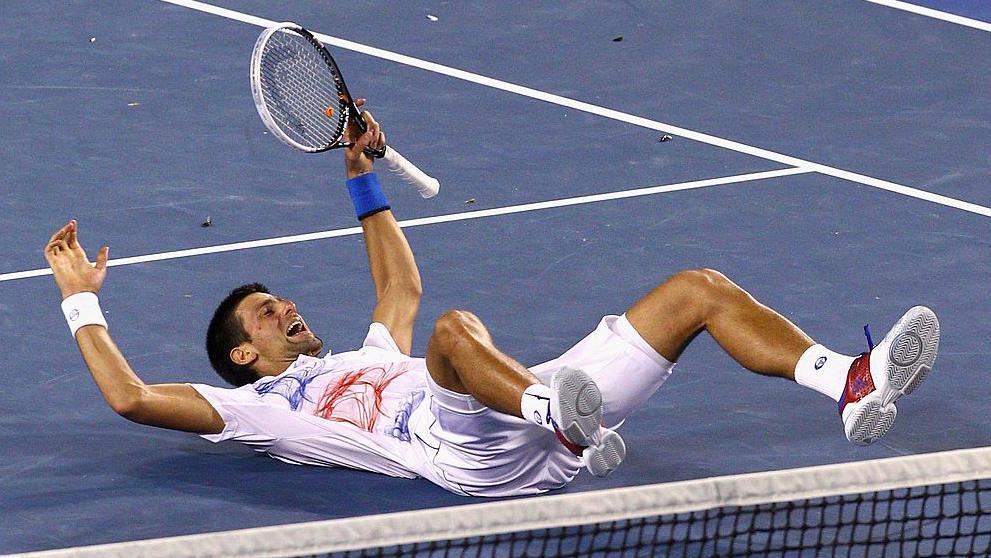 Novak Djokovic falls to the ground in celebration 