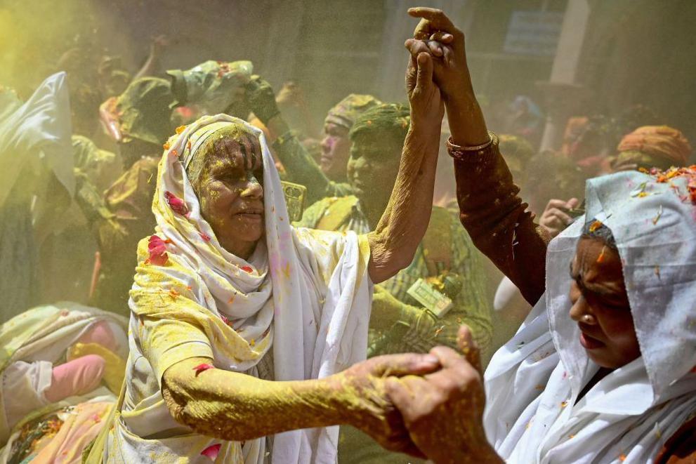 Widows smeared with gulal (coloured powder), dance as they celebrate Holi, the Hindu spring festival of colours, at a temple in Vrindavan on March 12, 2025.