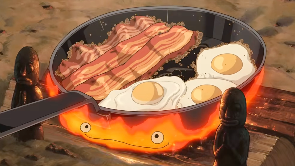 bacon and eggs in a pan being cooked on the fire of fire demon Calcifer in howl's moving castle.