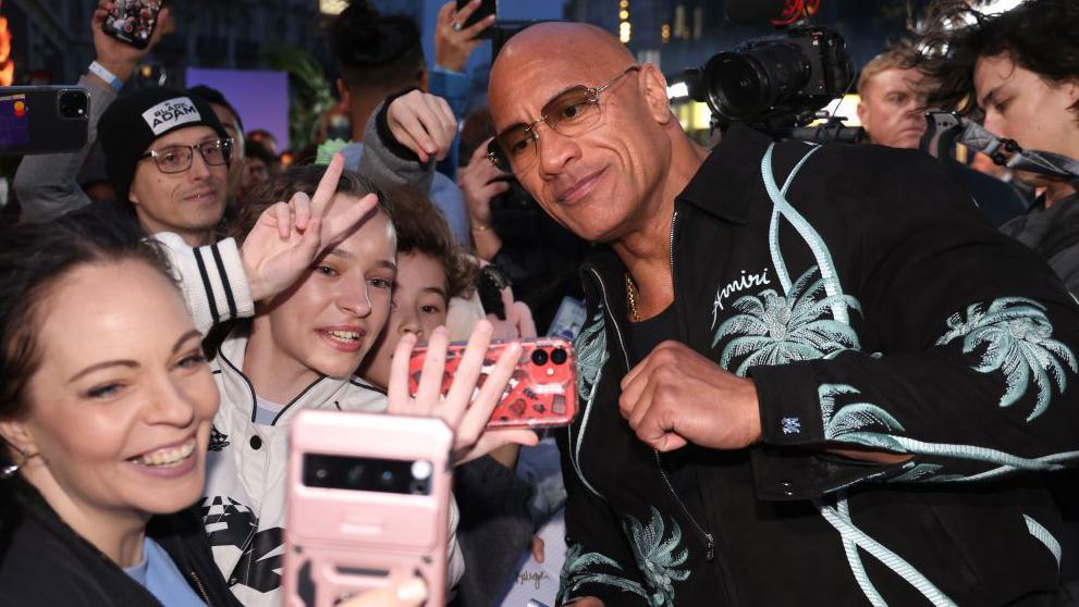 Dwayne 'The Rock' Johnson posing for photos with fans