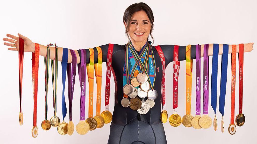 Dame Sarah Storey posing with her Paralympic medals
