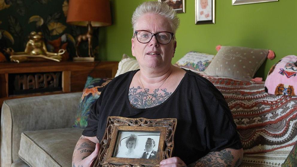 Sharon Askin holding picture of mother and father