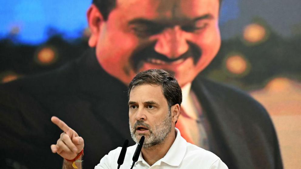 India's Congress party leader Rahul Gandhi addresses a press conference against the backdrop of a picture of Indian industrialist Gautam Adani, at his party headquarters in New Delhi on November 21, 2024.