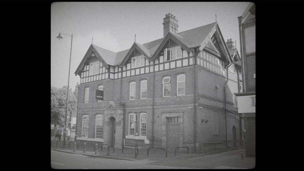 A black and white photo of the exterior of a pub