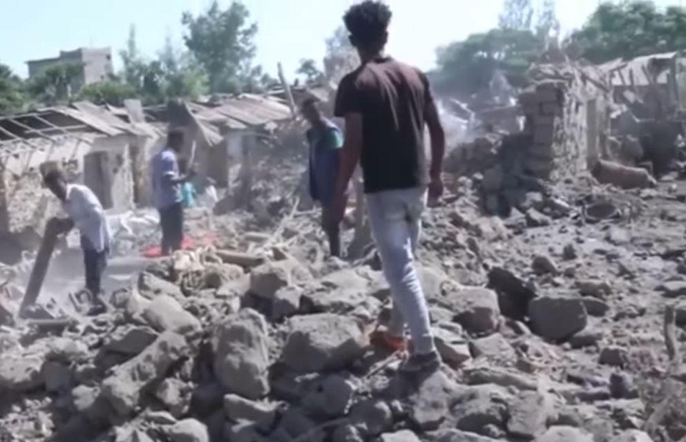 People searching through rubble from collapsed buildings