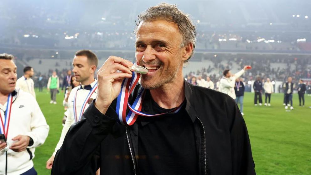 Luis Enrique bites his medal