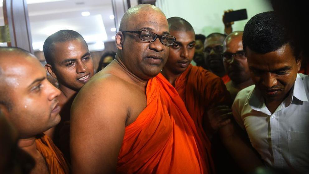 Galagodaatte Gnanasara, centre, leaves after a meeting with a Buddhist spiritual leader in 2019