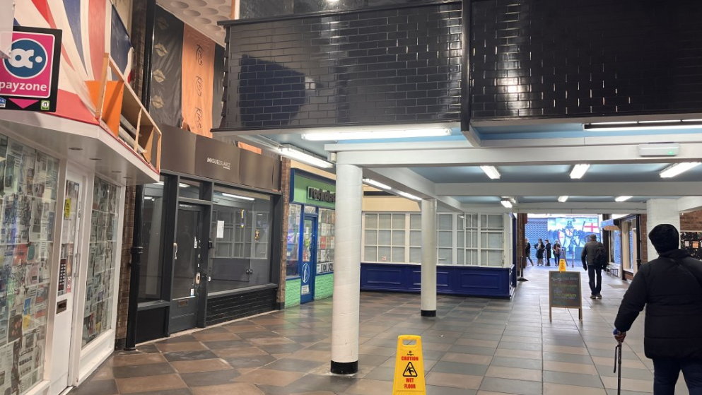 A shopping arcade with a handful of shoppers passing through