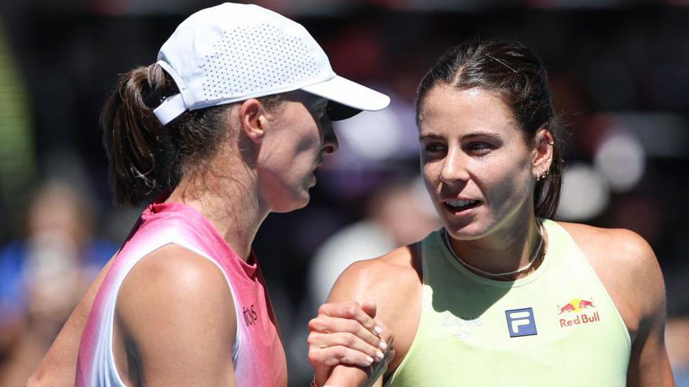 Iga Swiatek and Emma Navarro speak at the net after their Australian Open quarter-final