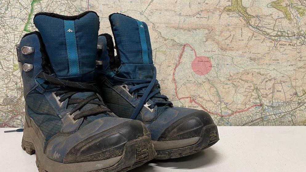 Pair of walking boots in front of a map of Kinder pass