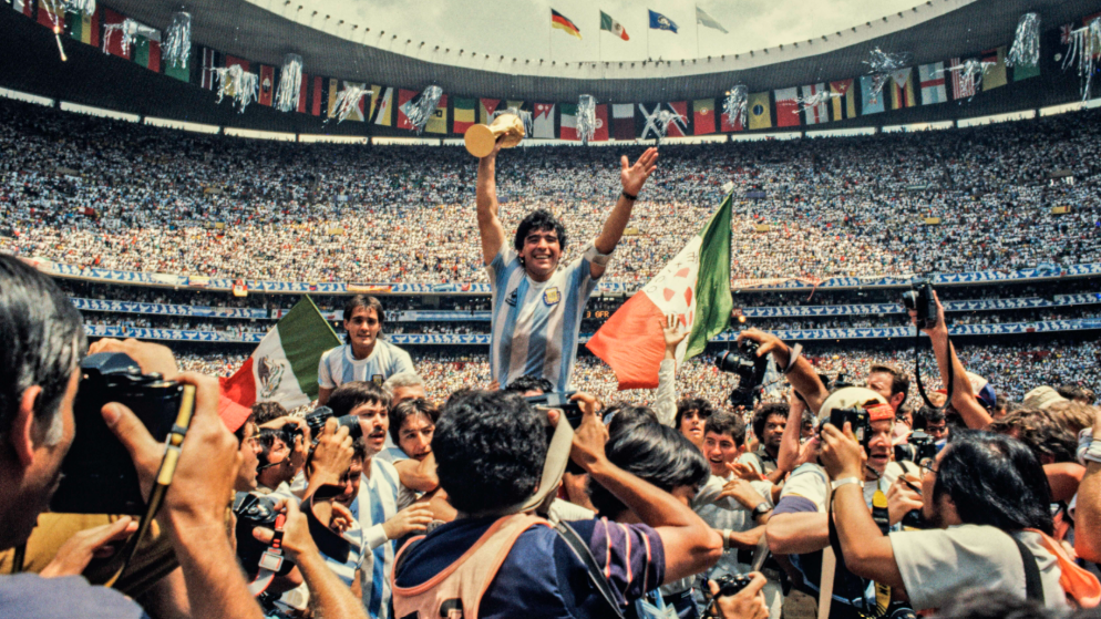 Diego Maradona of Argentina holding the World Cup trophy after being hoisted onto the shoulders of his team-mates at Estadio Azteca in Mexico City in 1986 