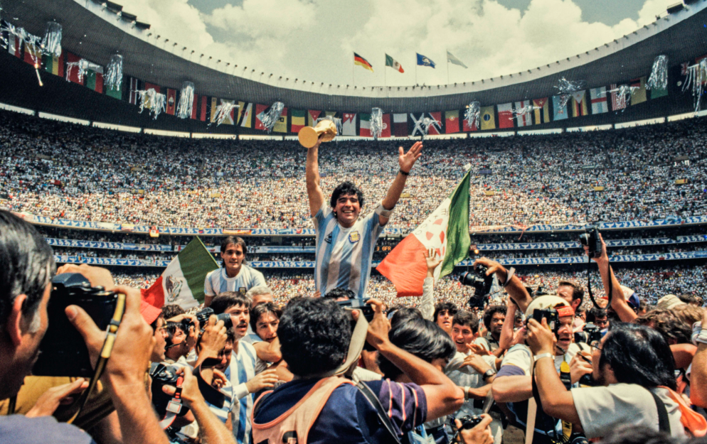 Diego Maradona of Argentina holding the World Cup trophy after being hoisted onto the shoulders of his team-mates at Estadio Azteca in Mexico City in 1986 