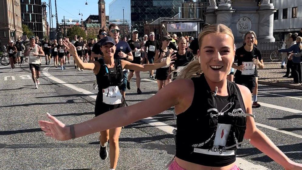 Lois Vidamour and Abi Tardival cheering running the marathon. 