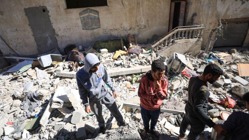 Civil defence teams and residents carry out search and rescue work at the destroyed houses after an Israeli attack on 19 March