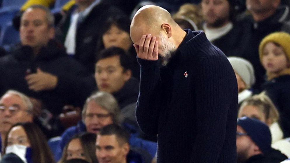 Pep Guardiola puts his hand to his face in frustration