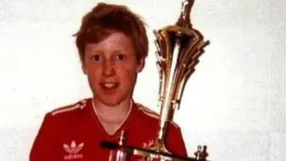 Philip Hammond, in his red Liverpool top, holding a trophy