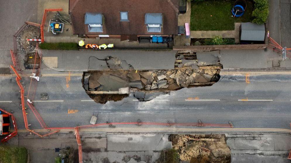 A drone view shows a large sinkhole in Godstone, southern Britain, February 19, 2025, with the gaping hole extending for metres along the high street with large areas taped off.