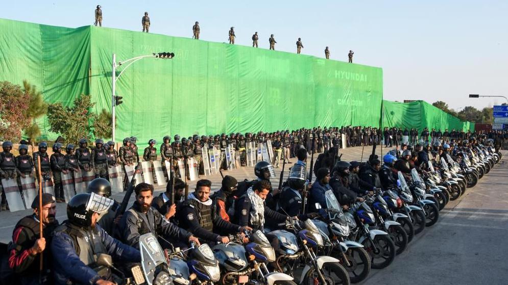 Police officers sit on motorbikes with shipping containers in the background, used to prevent an anti-government rally by supporters of the former Pakistani Prime Minister Imran Khan's party Pakistan Tehreek-e-Insaf (PTI), in Islamabad, Pakistan November 24, 2024