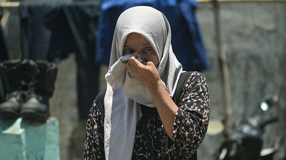 A relative of a missing student mourns as rescuers search for survivors 