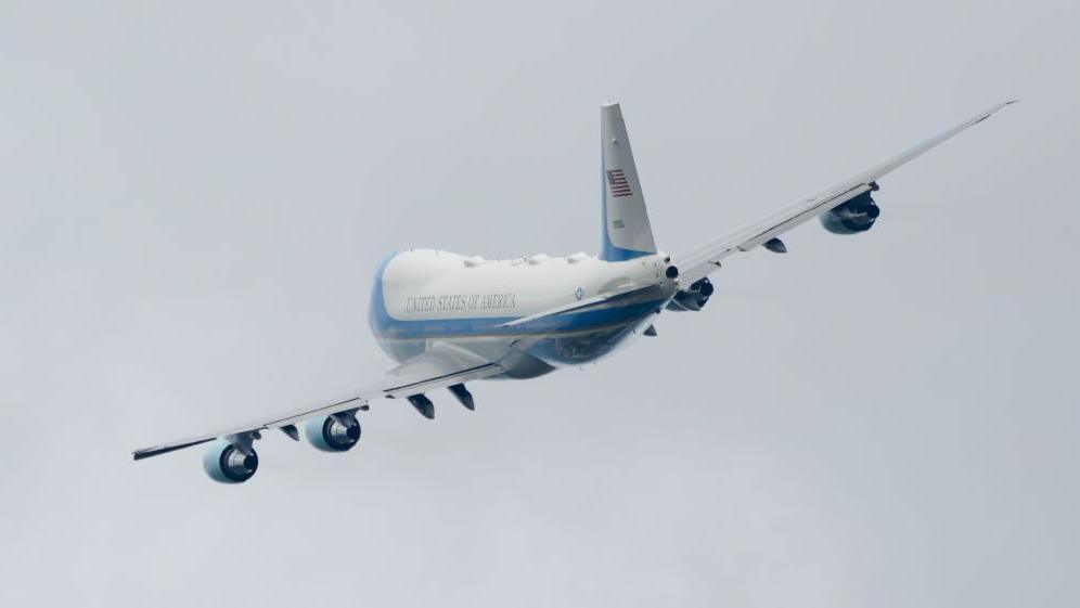 A plane banking against a grey sky