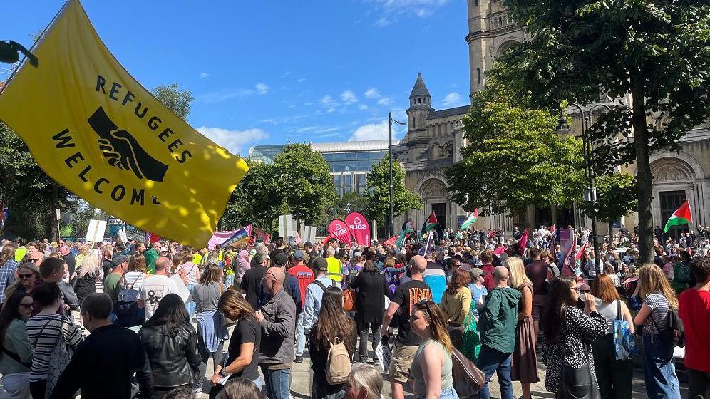 Marchers gathered in Writers' Square in Belfast with a "refugees welcome" flag