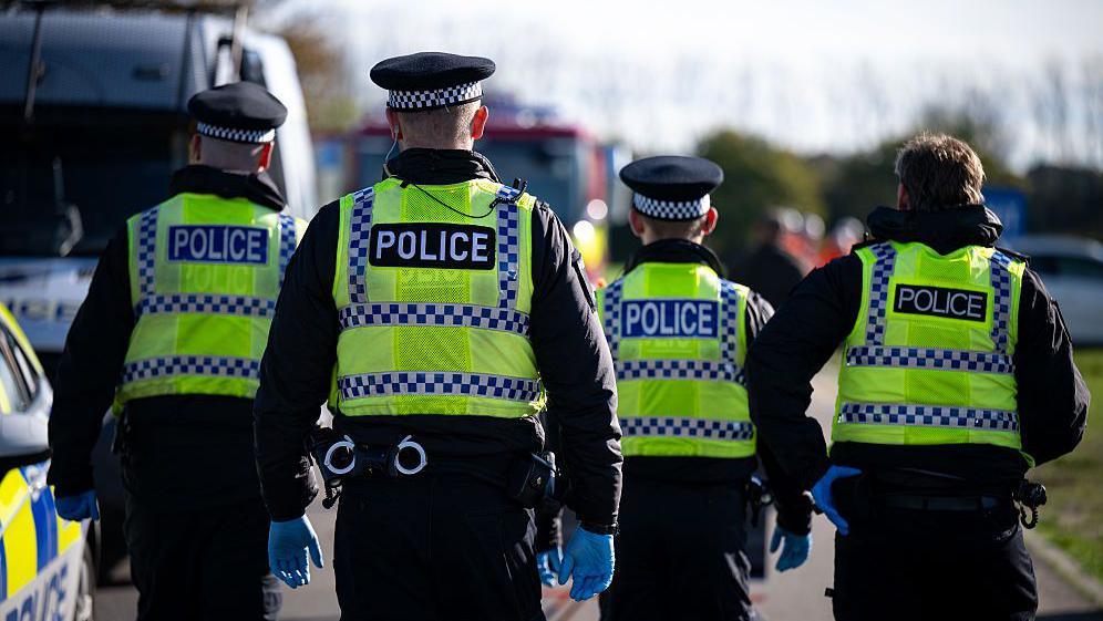 Four police officers search for a missing person during an emergency services test response to chemical incident as part of training exercise