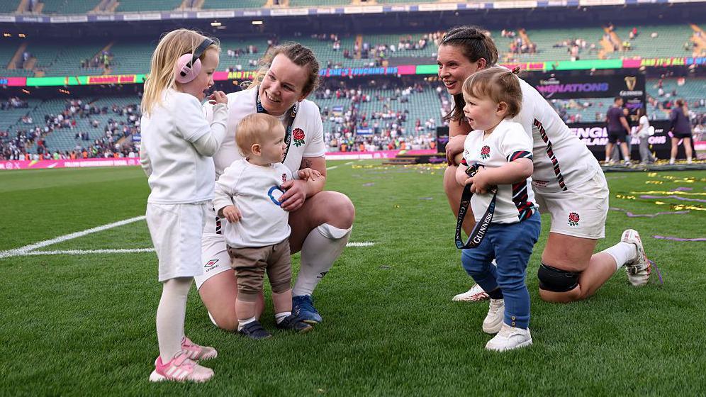 Lark Atkin-Davies and Abbie Ward with children on the Allianz Stadium pitch