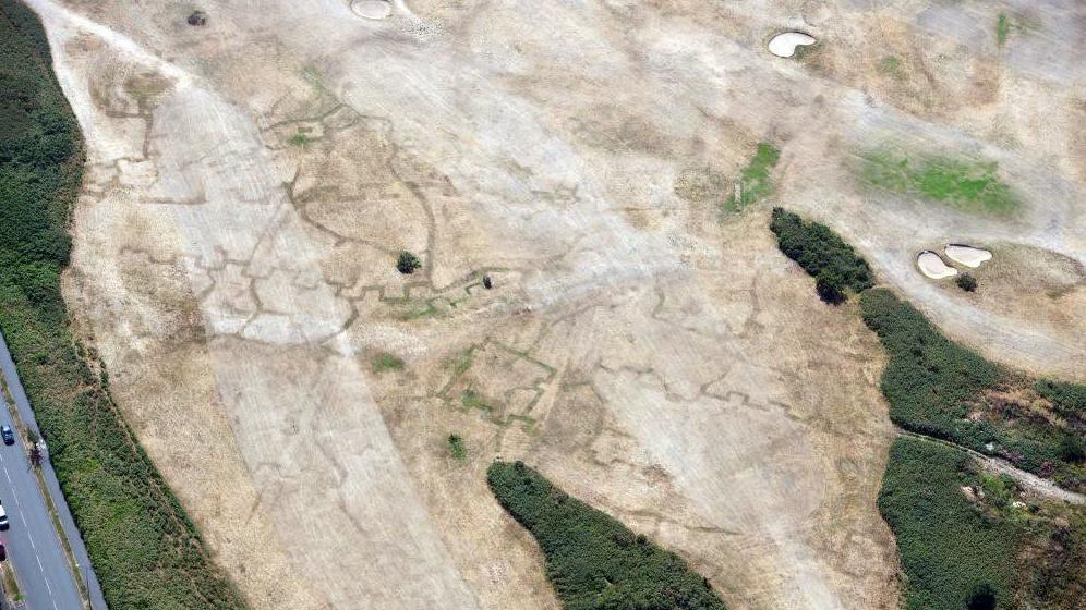 Dramatic archmarks of First World War practice trenches beneath a golf course at Deganwy, Conwy (17 July 2026).