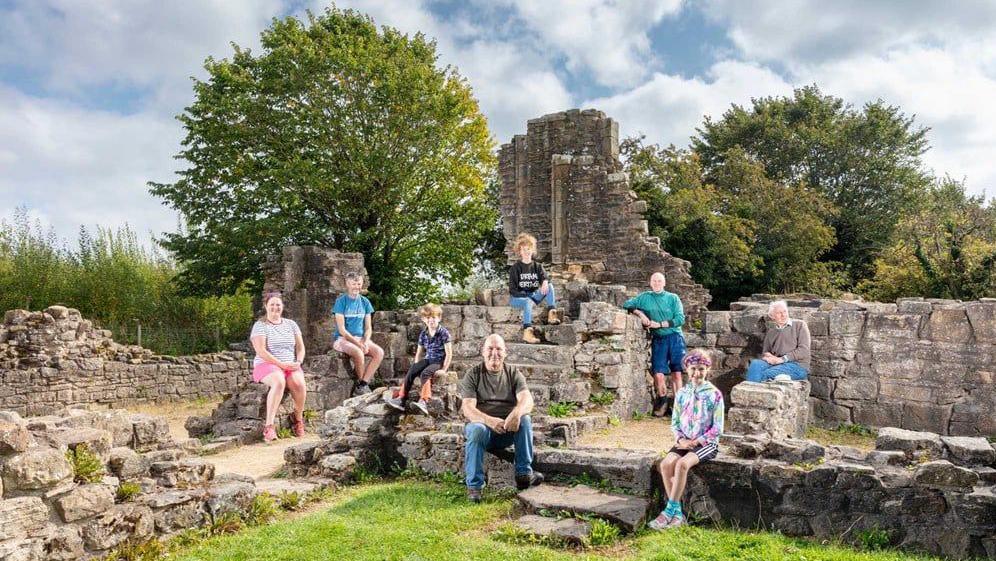 Volunteers of different ages sat around the medieval stone ruins of Beaurepaire.