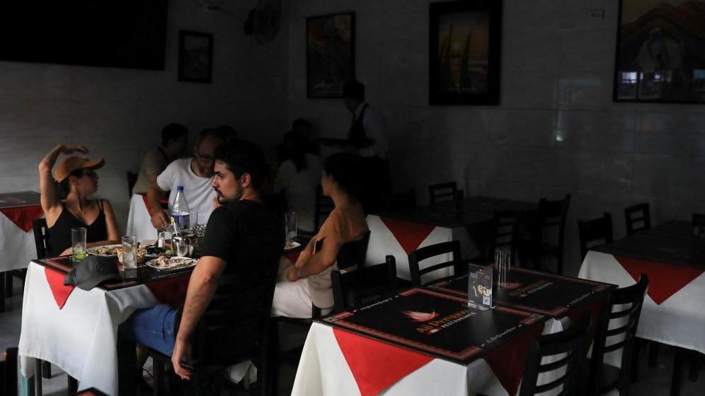 People sit inside a restaurant after a large power outage struck vast swaths of the country, in Santiago, Chile February 25, 2025.