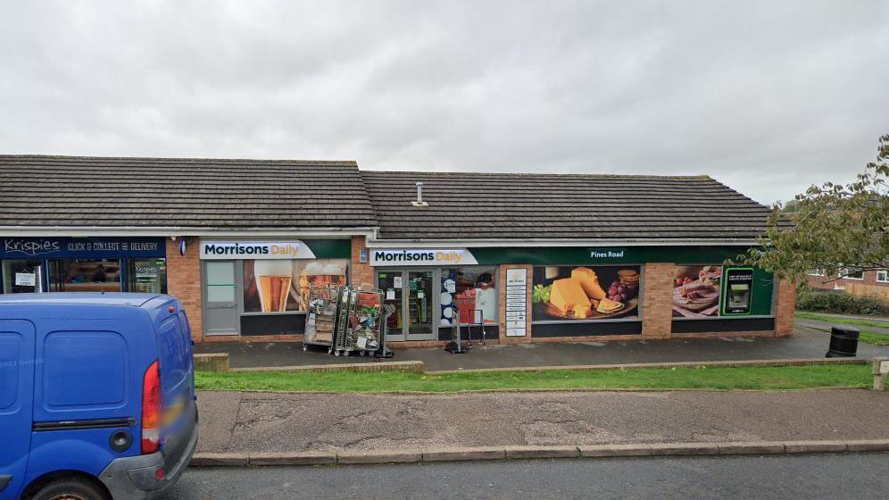 Google Street View of Morrisons Daily store in Pines Road, Exmouth. It is a cloudy day and a blue van is on the left-hand side of the photo.